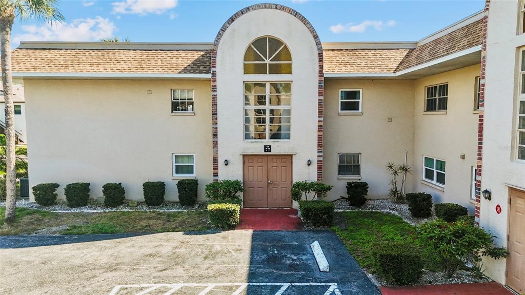 An exterior view of a two-story apartment building with a central arched entryway — 2727 75TH STREET W UNIT 8A2, BRADENTON, FL