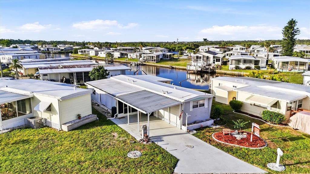 An aerial view shows several mobile homes situated along a narrow canal — 527 BLACKBURN BOULEVARD, NORTH PORT, FL