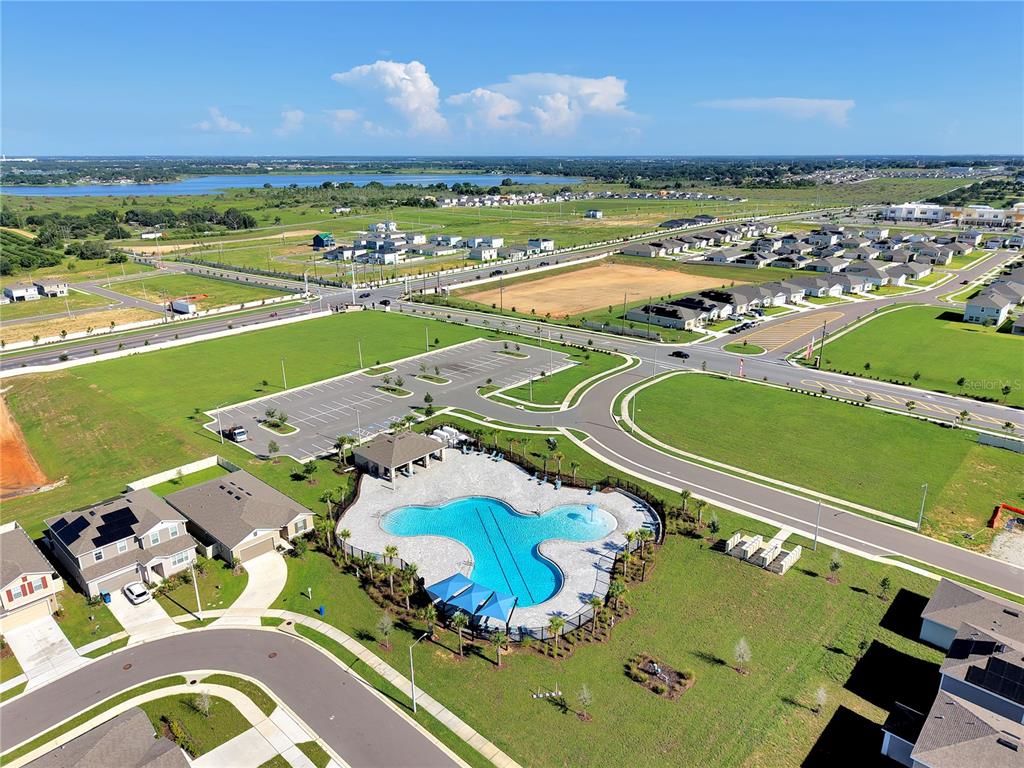 An aerial view shows a community swimming pool, parking lot, and surrounding residential neighborhood — 3008 DAFFODIL DRIVE, LAKE HAMILTON, FL