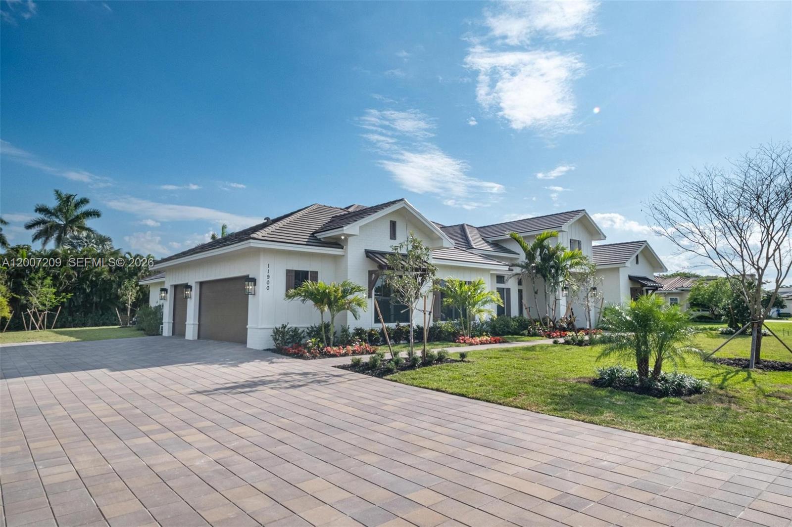 A white single-story house with a tiled roof, a paved driveway, and landscaped front yard — 11900 SW 14th Pl, Davie FL 33325, DAVIE, FL