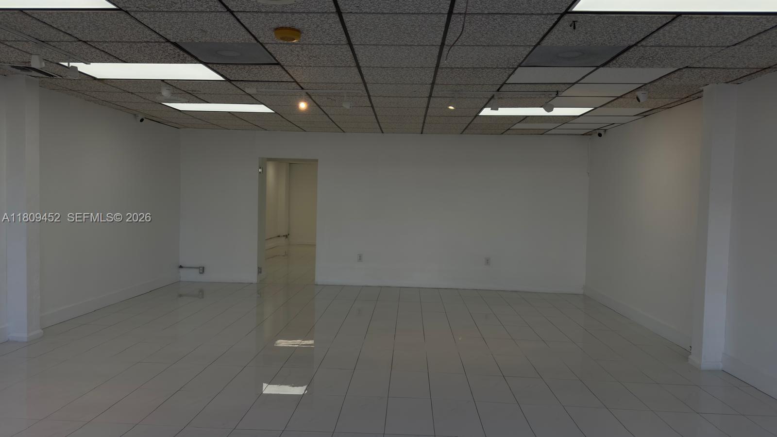 An empty commercial space features white walls, a tiled floor, and a drop ceiling — 3960 W 16th Ave # 204, Hialeah FL 33012, HIALEAH, FL
