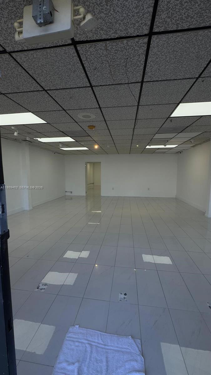 An empty commercial space features white tiled floors, white walls, and a drop ceiling — 3960 W 16th Ave # 204, Hialeah FL 33012, HIALEAH, FL