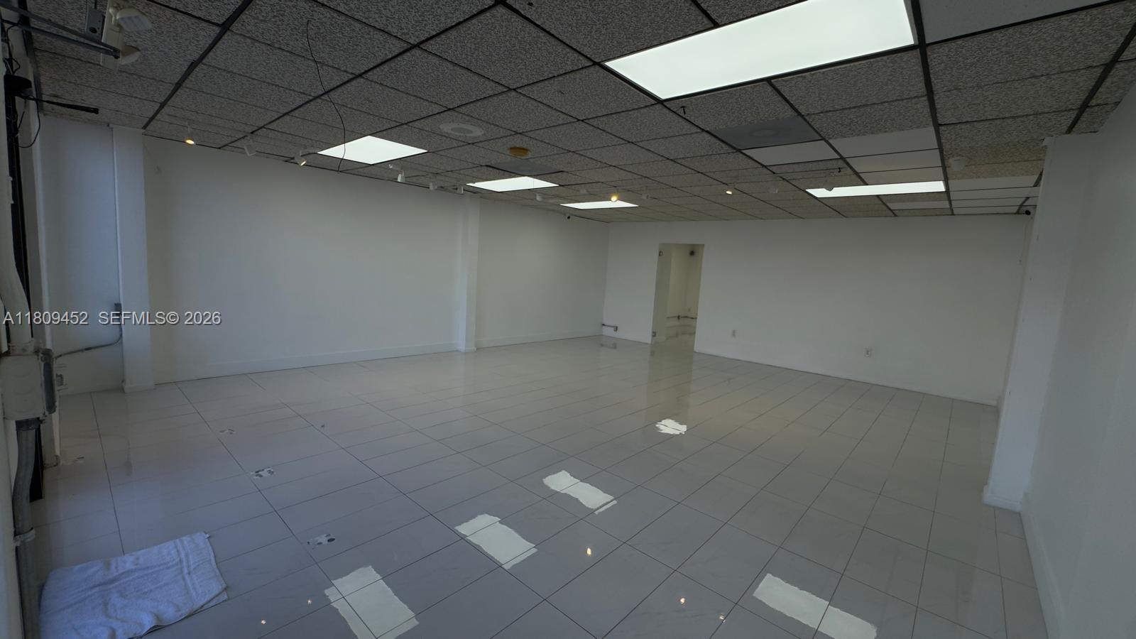 An empty commercial space features white tiled floors, white walls, and a drop ceiling — 3960 W 16th Ave # 204, Hialeah FL 33012, HIALEAH, FL