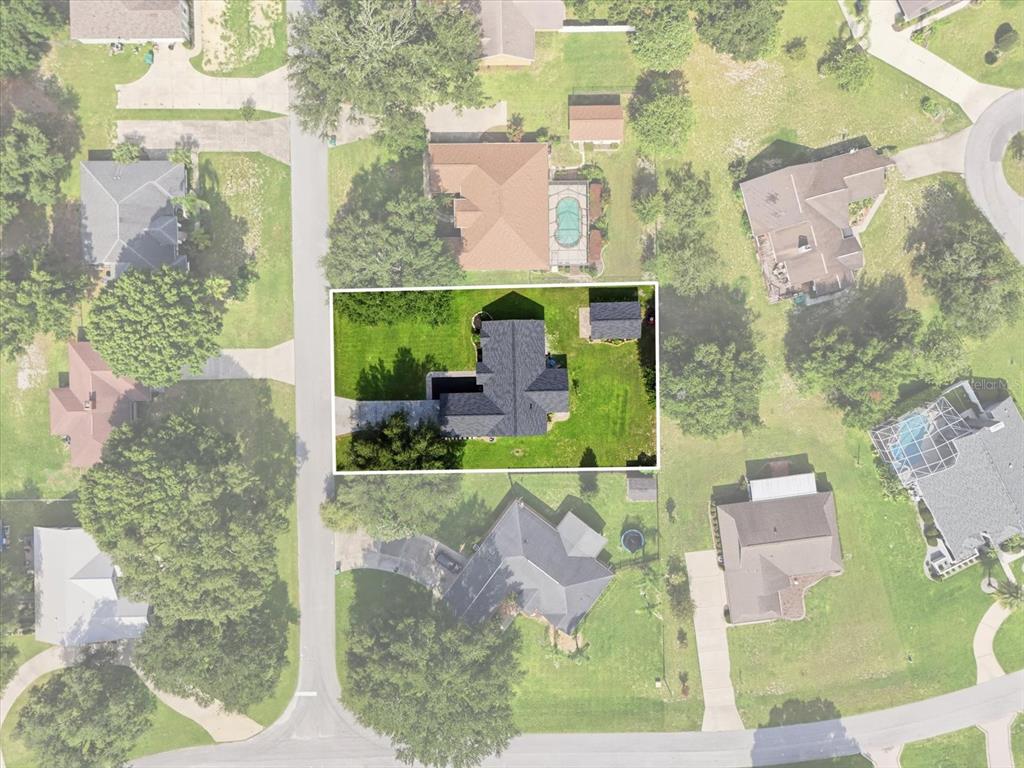 An aerial view shows a single-family home with a yard and detached shed — 9285 COUNTY ROAD 125B, WILDWOOD, FL