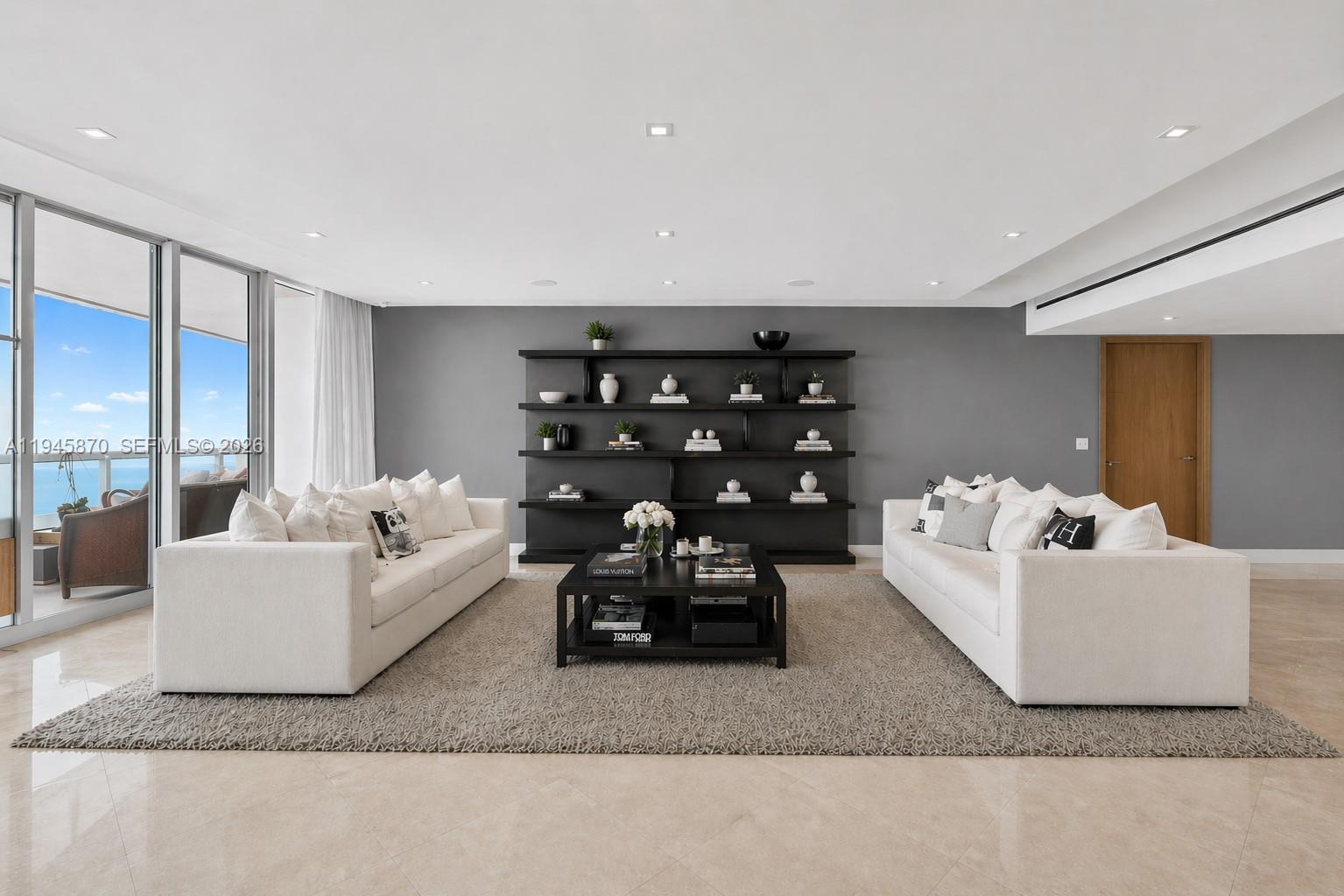 A living room features two white sofas, a central coffee table, and a dark shelving unit — 1643 Brickell Ave # 3904, Miami FL 33129, MIAMI, FL