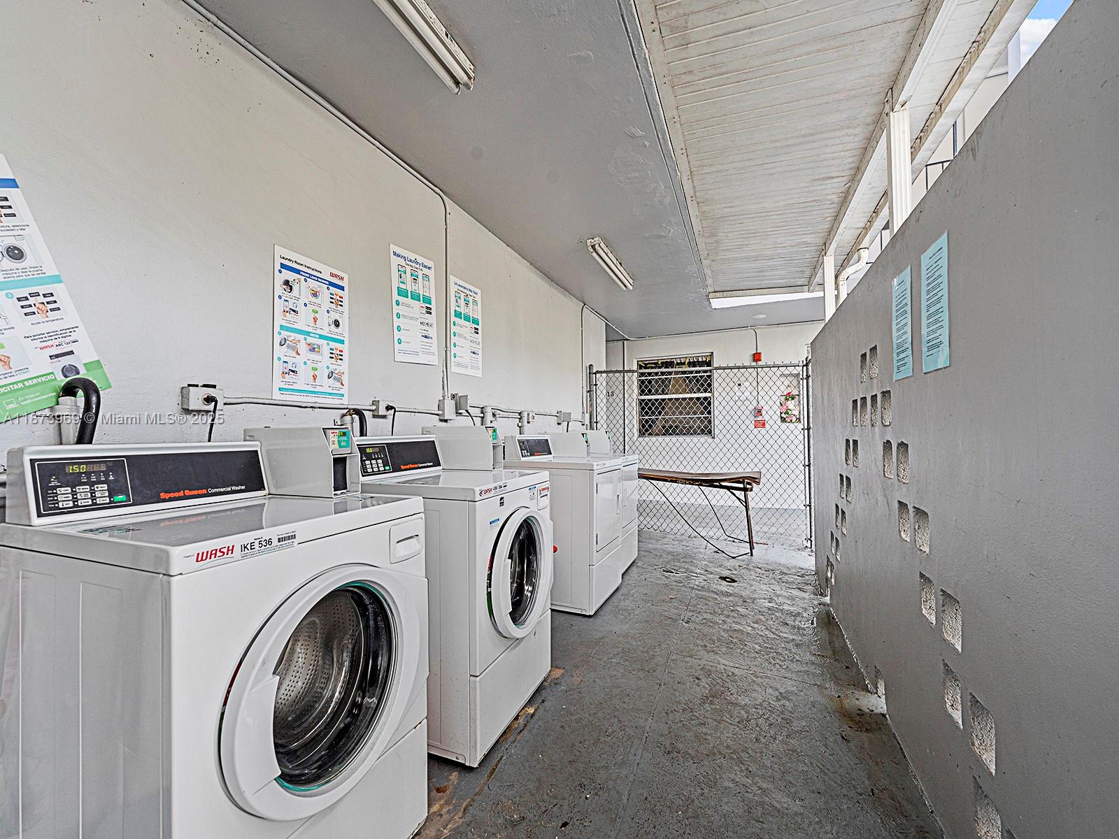 A covered outdoor laundry area features three white washing machines and a folding table — 10305 SW 40th St # 0, Miami FL 33165, MIAMI, FL