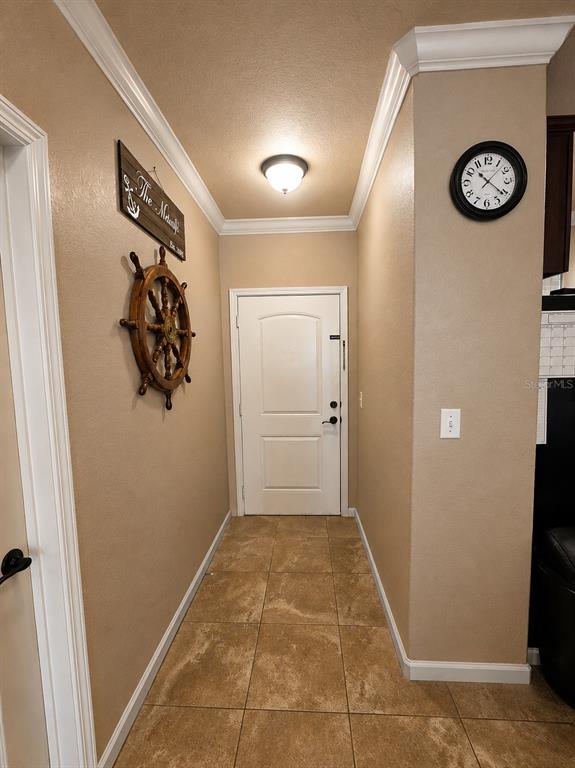 A tiled entryway features a white door, a ship's wheel wall decor, and a wall clock — 901 CHARO PARKWAY UNIT 714, DAVENPORT, FL