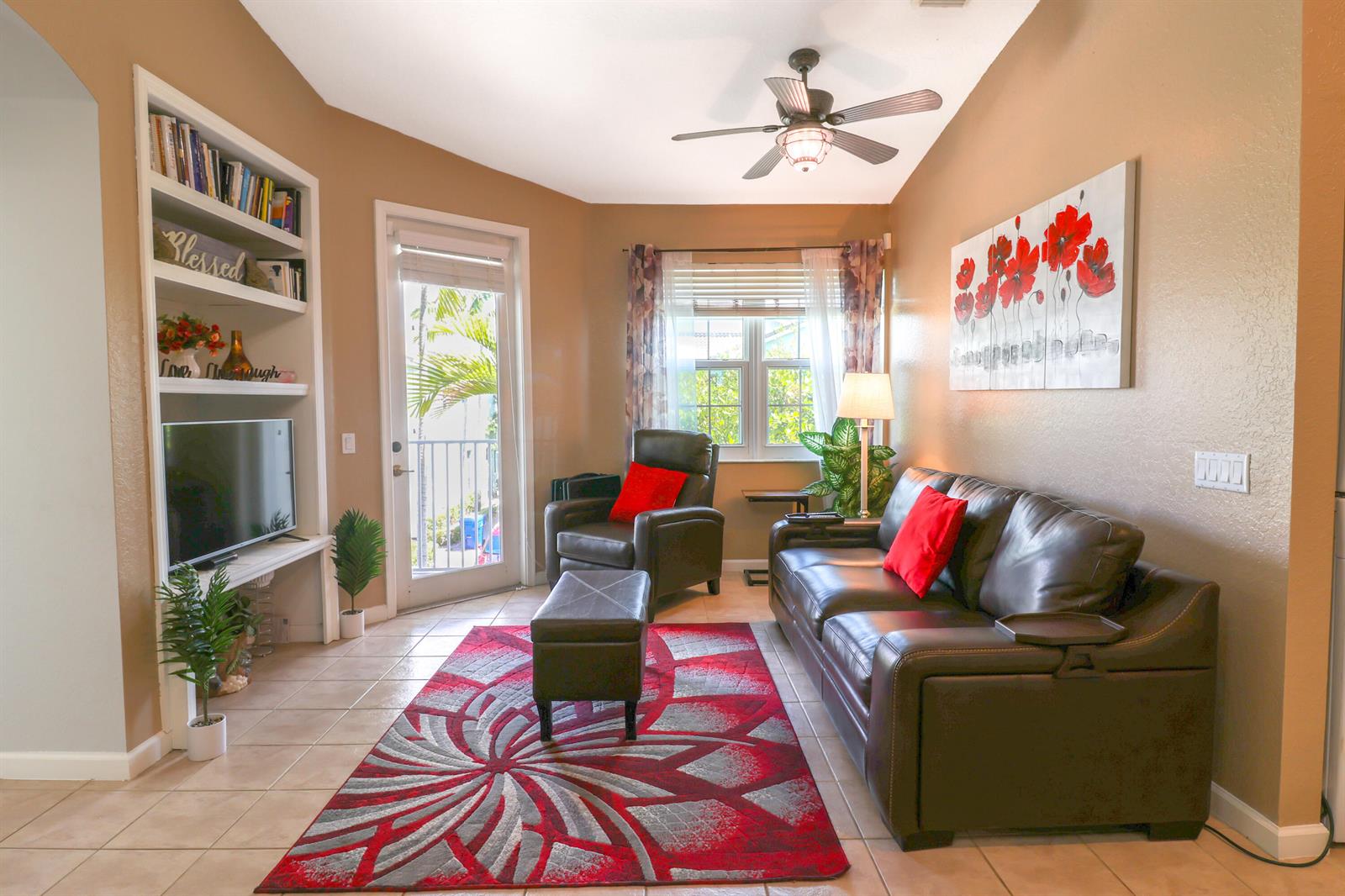 A living room features a leather sofa, armchair, patterned rug, and a built-in media center — 3133 Laurel Ridge Circle, West Palm Beach FL 33404, WEST PALM BEACH, FL