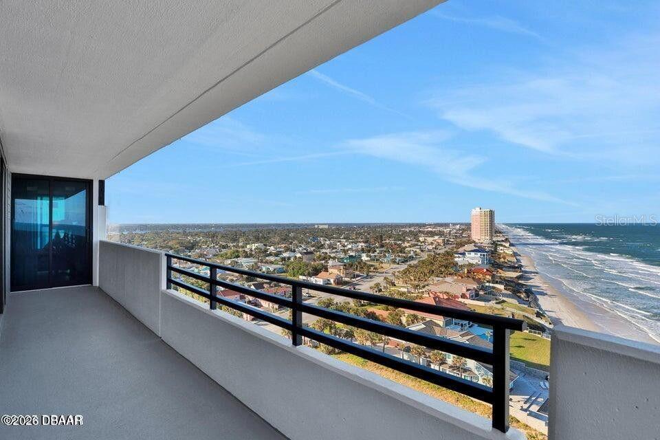 A high-rise balcony overlooks a coastal town and the ocean — 1420 N ATLANTIC AVENUE UNIT 901, DAYTONA BEACH, FL