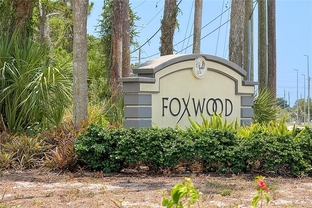 A stone monument sign for Foxwood stands in front of trees and landscaping — 206 ASPEN STREET, ENGLEWOOD, FL