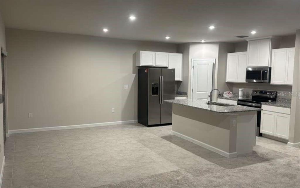 A kitchen with white cabinets, stainless steel appliances, and a granite-topped island — 347 BILTMORE BOULEVARD, DUNDEE, FL