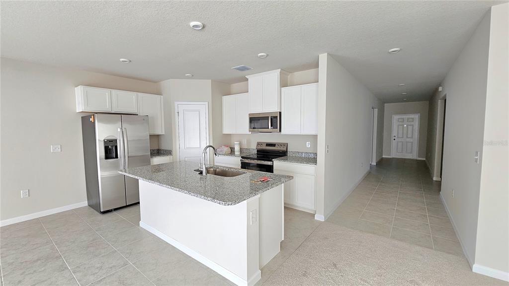A kitchen with white cabinets, granite countertops, a center island, and stainless steel appliances — 347 BILTMORE BOULEVARD, DUNDEE, FL