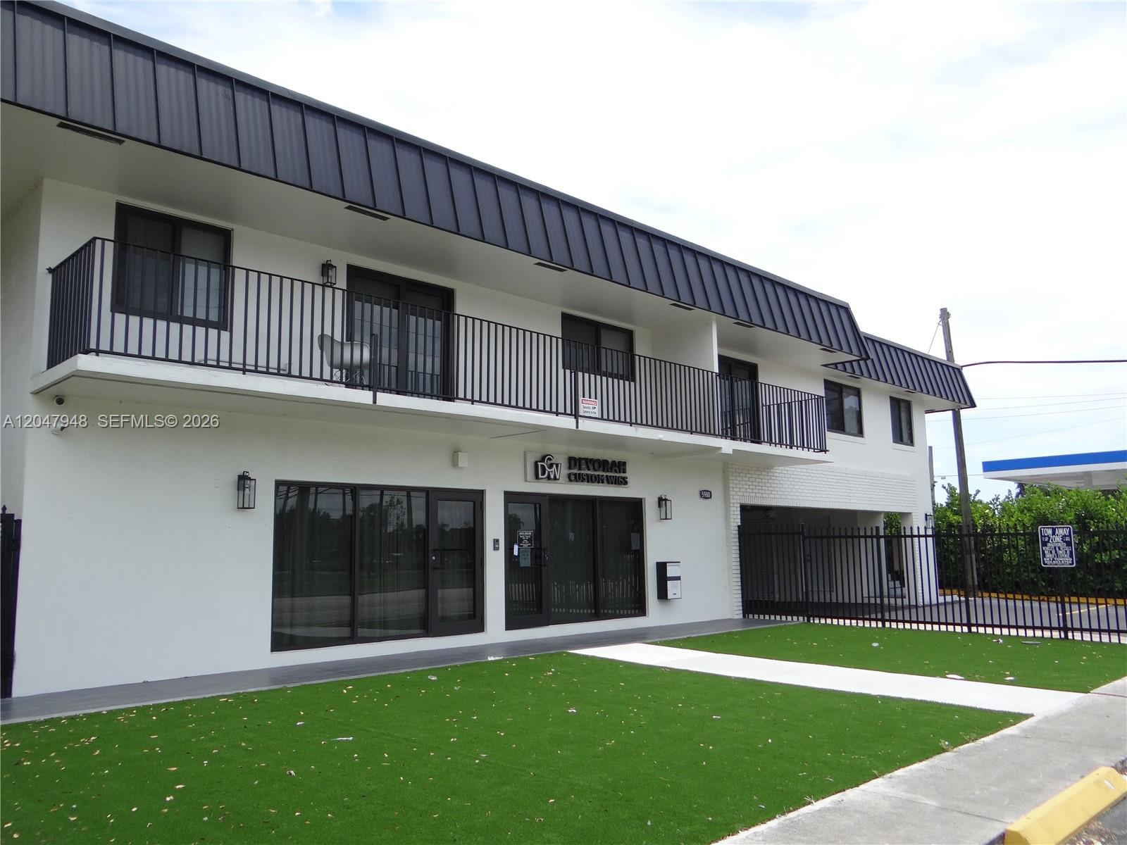A two-story commercial building with a black metal roof, white facade, and artificial turf lawn — 5980 SW 40th Ave # D, Dania Beach FL 33312, DANIA BEACH, FL