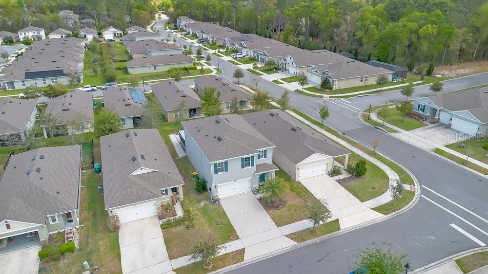 An aerial view shows a suburban neighborhood with multiple single-family homes and paved streets — 410 LADY BELLA PLACE, DELAND, FL