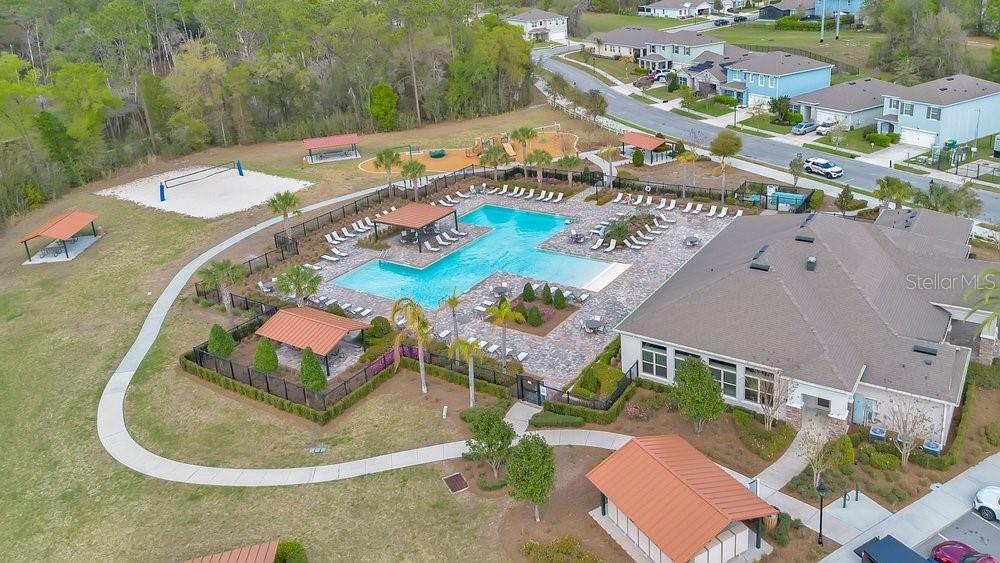 An aerial view shows a community clubhouse with a swimming pool, playground, and sports court — 410 LADY BELLA PLACE, DELAND, FL