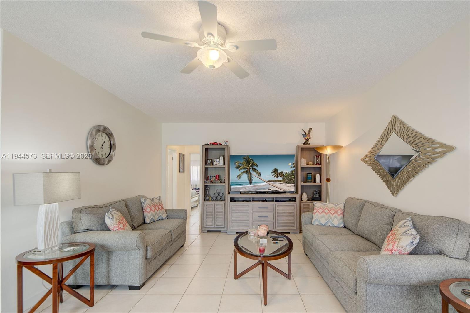 A living room features two gray sofas, a central coffee table, and an entertainment center — 800 SW 11th Ave # 9A, Hallandale Beach FL 33009, HALLANDALE BEACH, FL