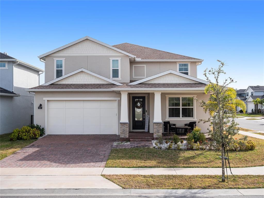 A two-story suburban house features a beige stucco exterior, a two-car garage, and a porch — 3437 MCLAIN PRESERVE POINT, SANFORD, FL