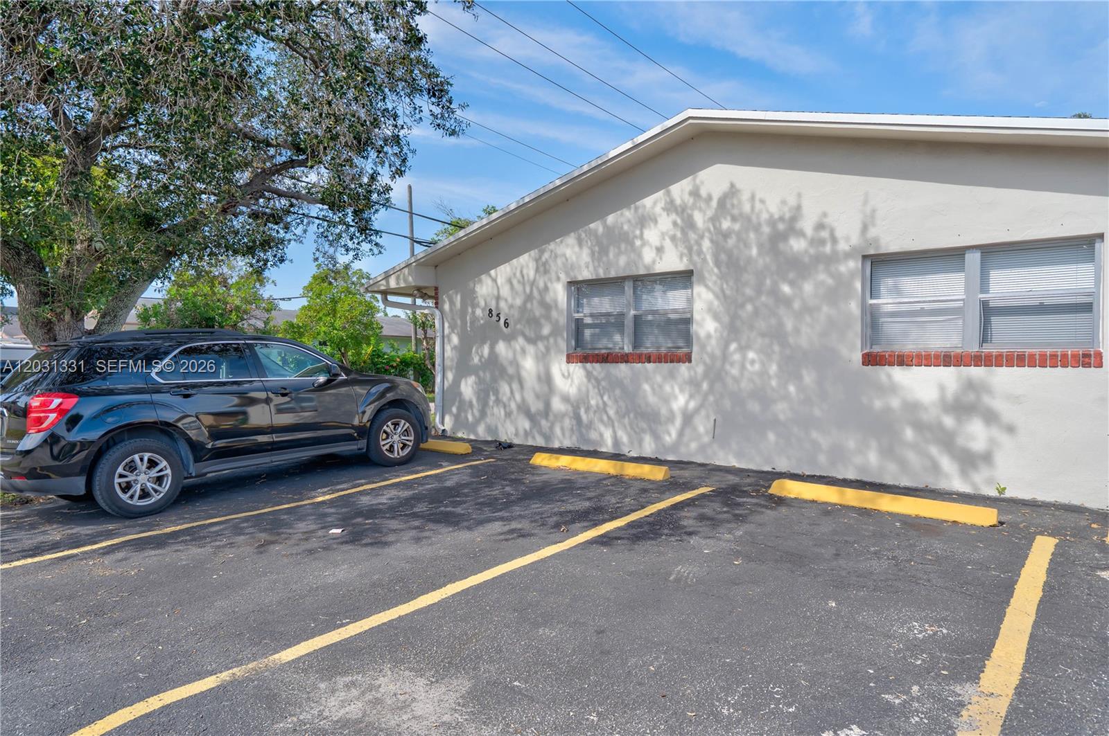 A black SUV is parked in front of a one-story building with two windows — 856 SW 10th St # 1, Hallandale Beach FL 33009, HALLANDALE BEACH, FL