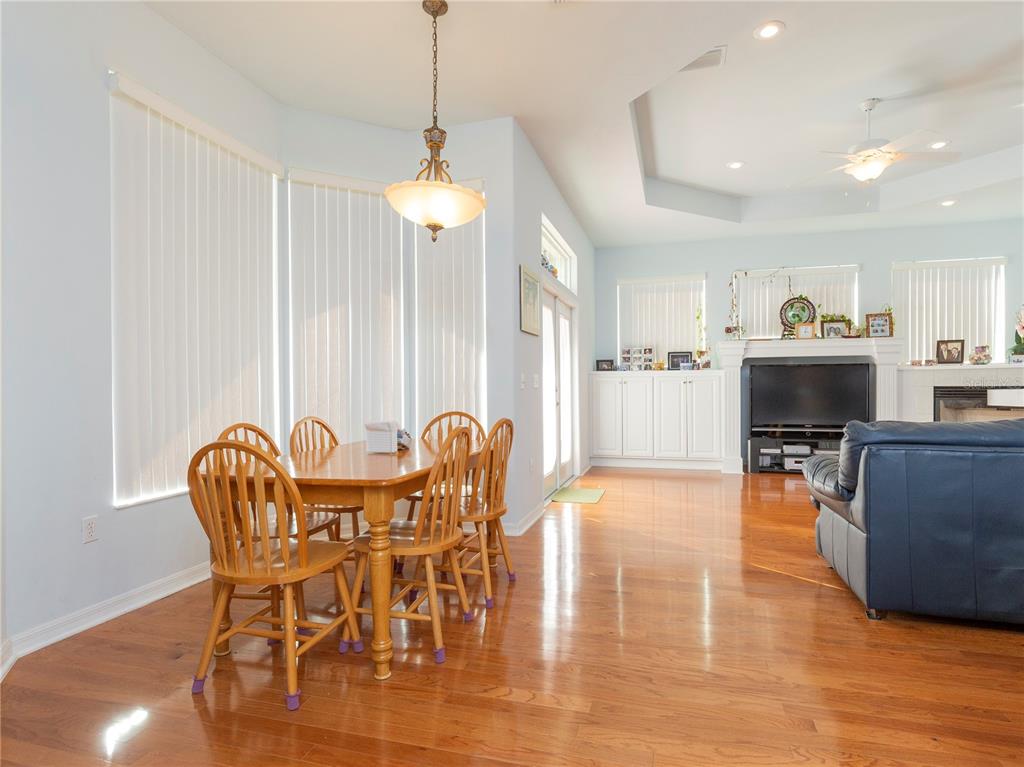 A dining area with a wooden table and chairs sits next to a living room — 1486 SW 87TH STREET, GAINESVILLE, FL