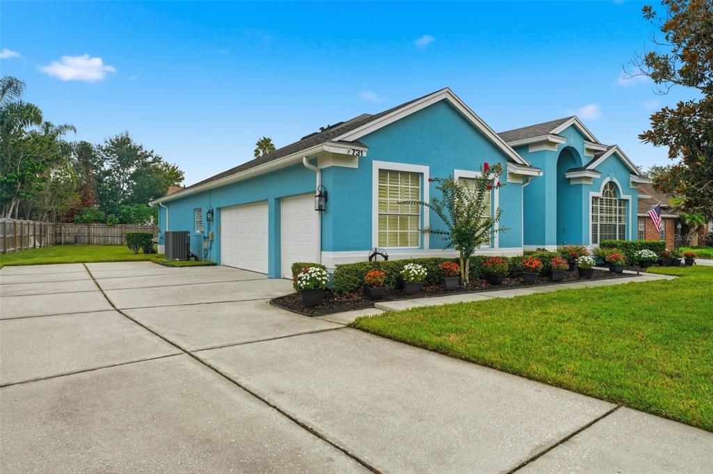A blue single-story house with a two-car garage and a concrete driveway — 731 DIVINE CIRCLE, ORLANDO, FL