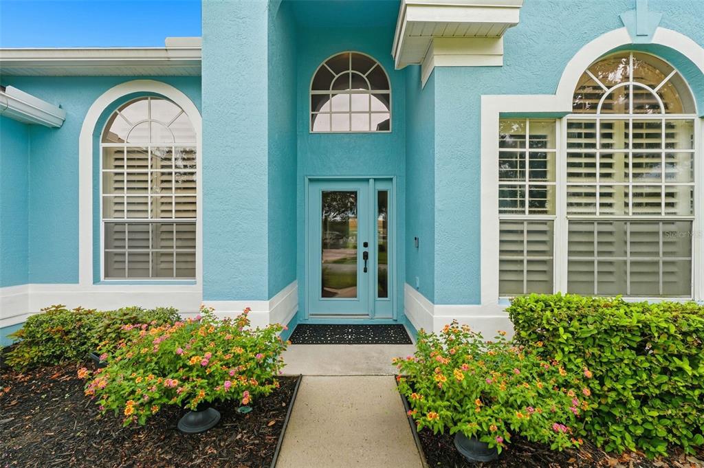 The exterior of a blue house features a glass front door and arched windows — 731 DIVINE CIRCLE, ORLANDO, FL