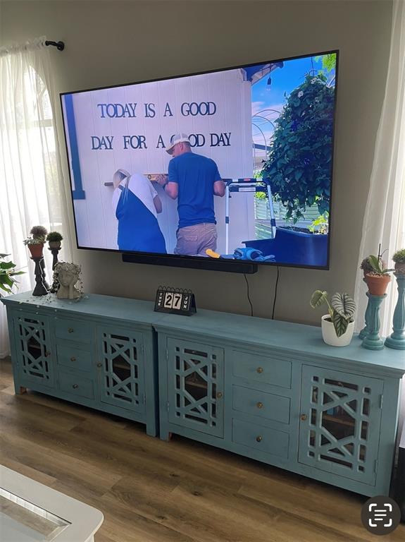 A wall-mounted television sits above two matching blue wooden cabinets in a living room — 1826 EAGLE RIDGE BOULEVARD, PALM HARBOR, FL