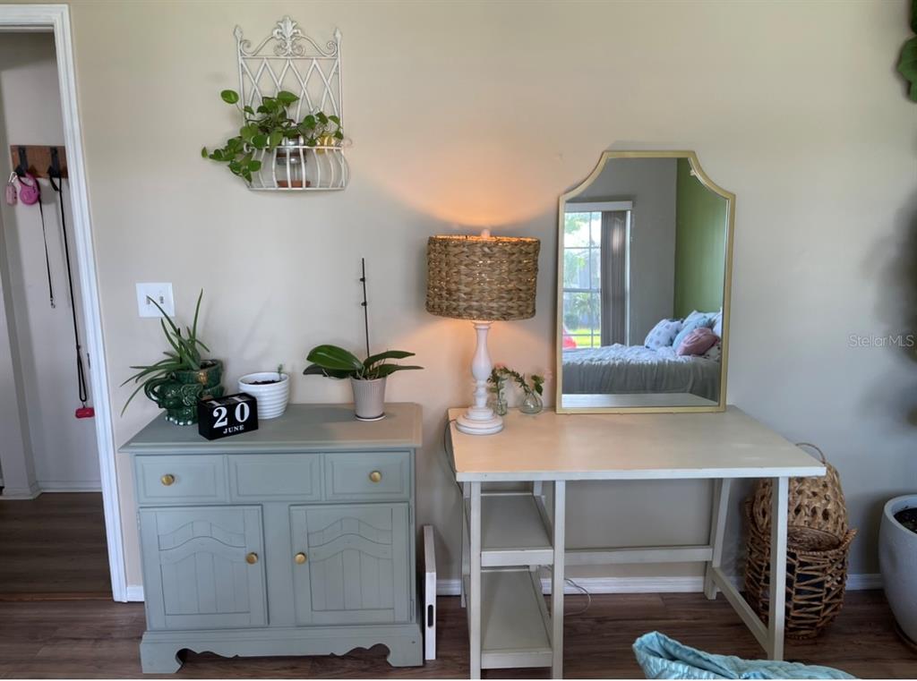 A light blue cabinet and a white desk with a mirror sit against a beige wall — 1826 EAGLE RIDGE BOULEVARD, PALM HARBOR, FL