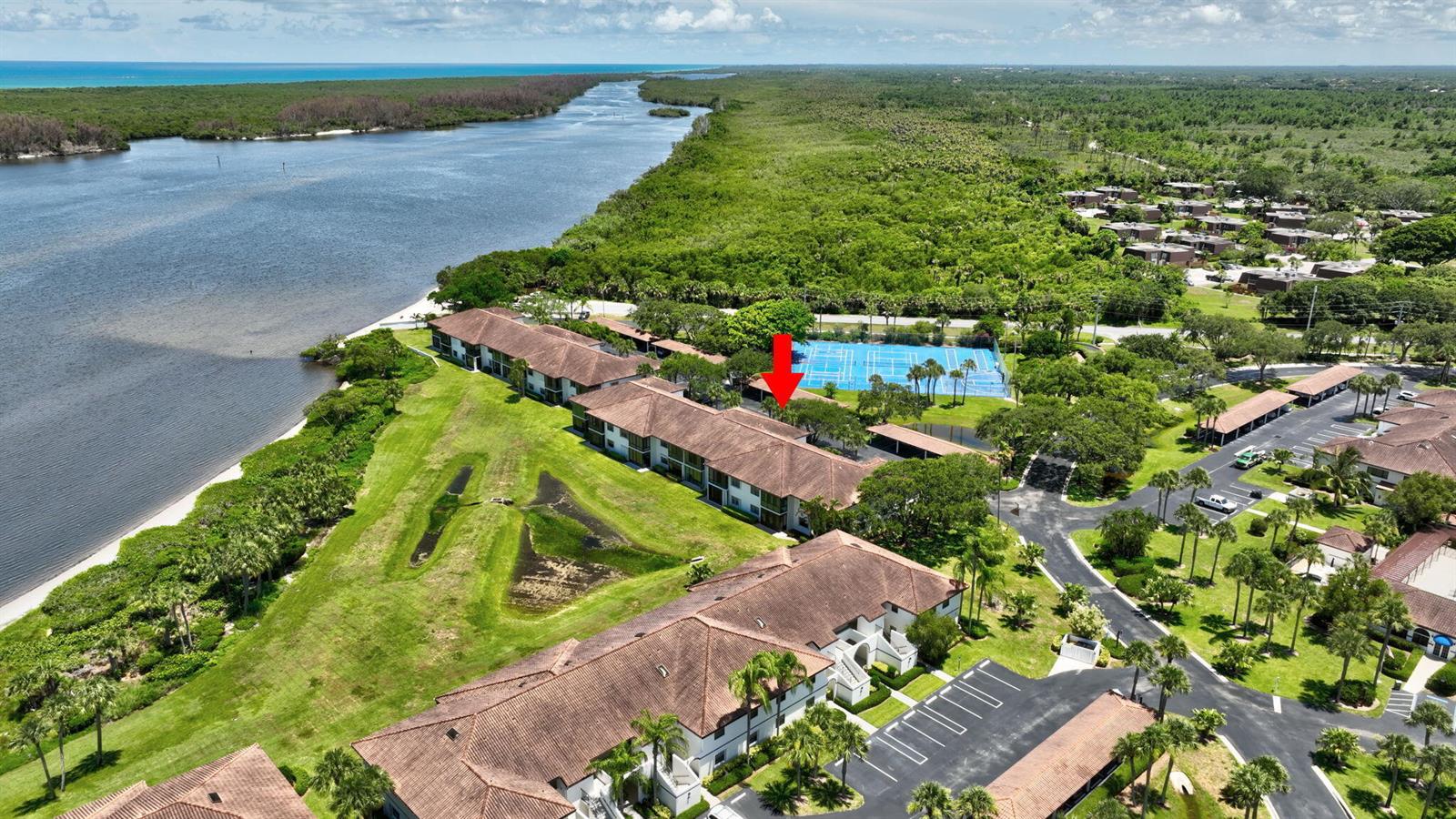 An aerial view shows multi-story residential buildings, a tennis court, and a nearby waterway — 6062 SE Landing Way # 2, Stuart FL 34997, STUART, FL