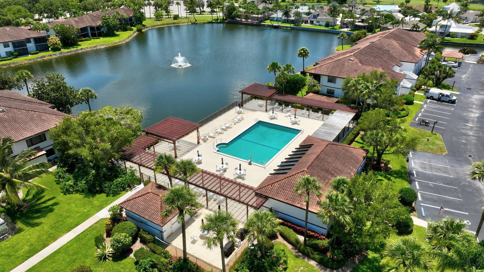 An aerial view of a swimming pool and patio area next to a lake — 6062 SE Landing Way # 2, Stuart FL 34997, STUART, FL