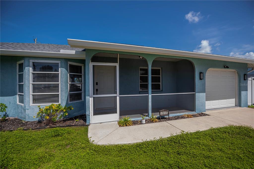 A light blue house exterior features a screened front porch and a single-car garage — 1510 NANTUCKET ROAD, VENICE, FL