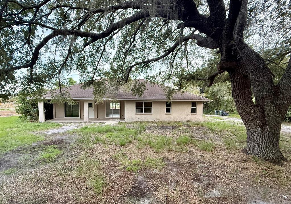 A single-story house with a covered porch sits beneath a large, sprawling oak tree — 3500 W PRICE BOULEVARD, NORTH PORT, FL