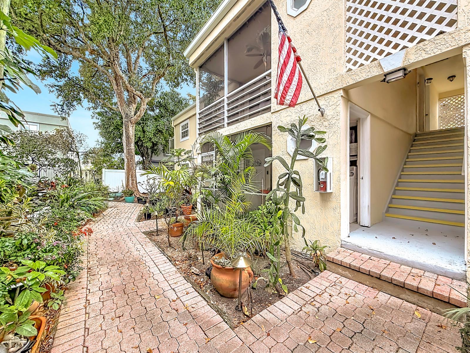 A brick walkway leads to a building entrance with stairs and potted plants — 305 SE 11th Avenue, Pompano Beach FL 33060, POMPANO BEACH, FL