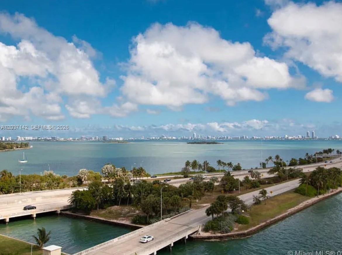 An aerial view shows a highway bridge crossing over water with a city skyline in distance — 600 NE 36th St # 1006, Miami FL 33137, MIAMI, FL