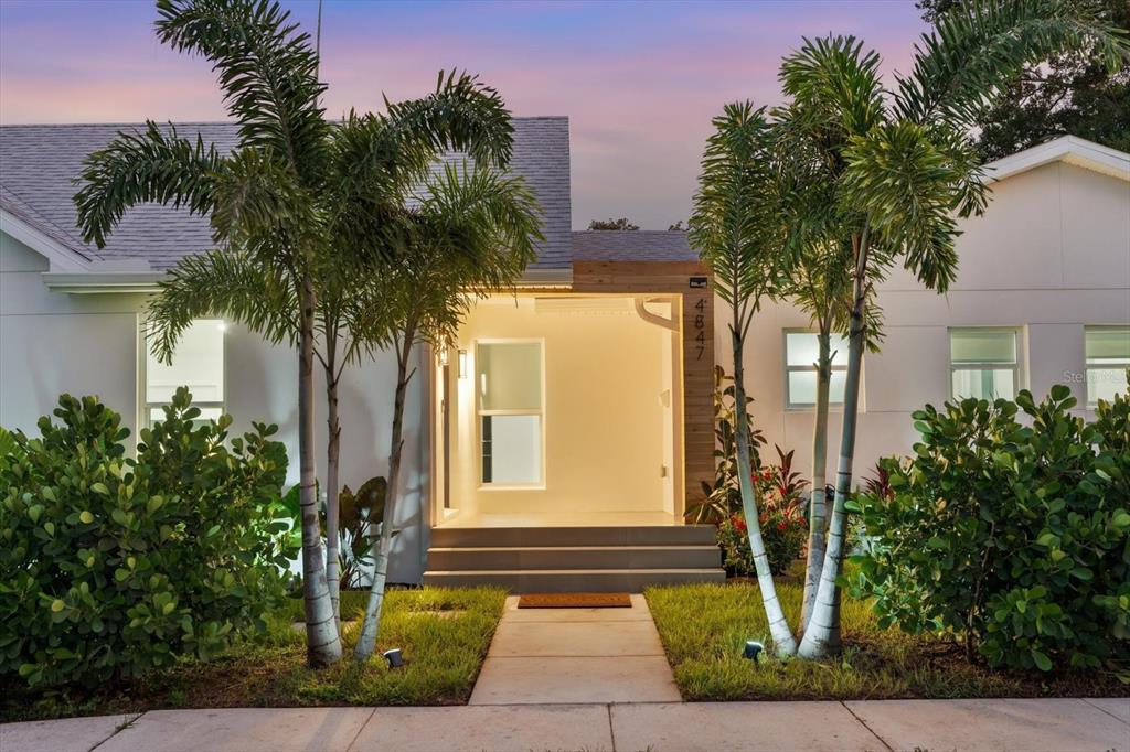 A modern house exterior features a recessed wood-paneled entryway, palm trees, and a concrete walkway — 4847 DR MARTIN LUTHER KING JR STREET N, ST PETERSBURG, FL