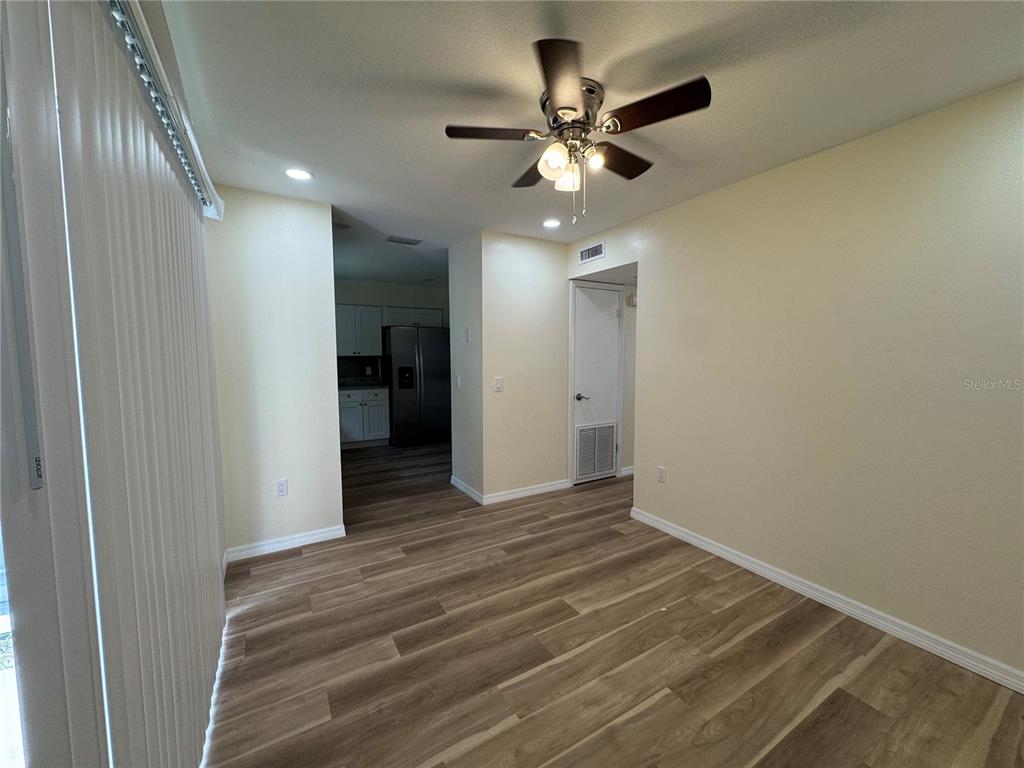 A dining area with wood-look flooring, a ceiling fan, and a view into the kitchen — 665 W JUNIATA STREET, CLERMONT, FL