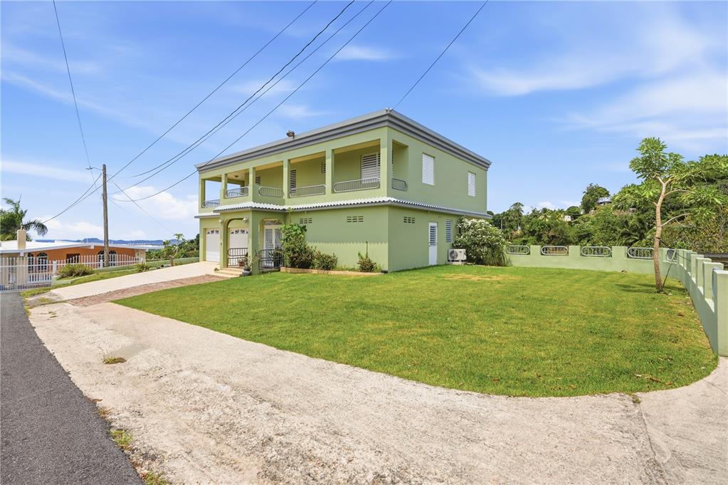 A two-story light green house with a balcony and a large grassy yard — 831 SECTOR LOS TORRES BO. MINILLAS UNIT 5.2, BAYAMON, PR