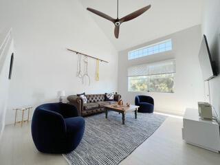 A living room with a vaulted ceiling, a ceiling fan, a sofa, and two armchairs — 606 Mainsail Circle, Jupiter FL 33477, JUPITER, FL