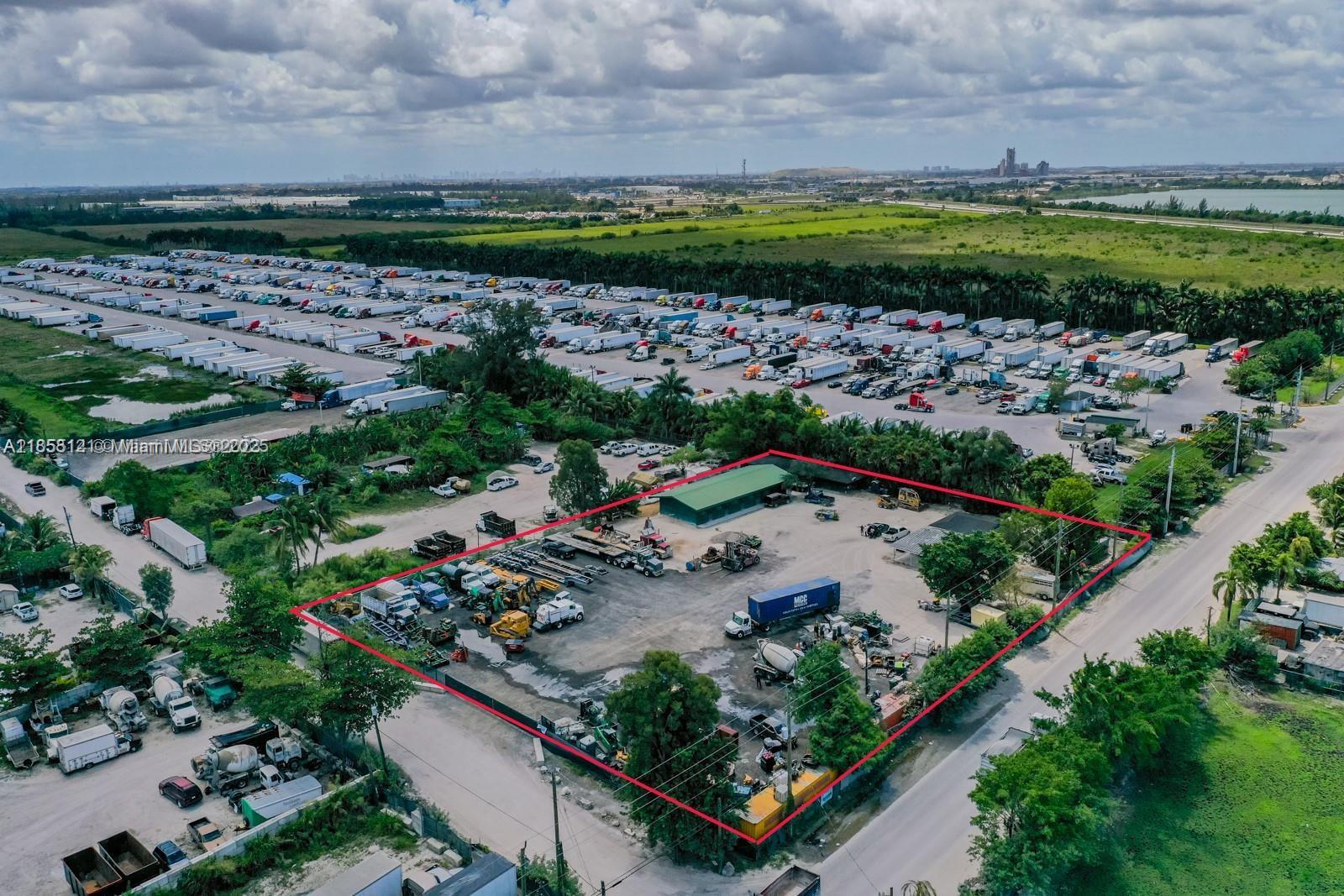 An aerial view shows a fenced industrial lot with a warehouse and various parked vehicles — 12160 NW 157 st, Miami FL 33018, MIAMI, FL