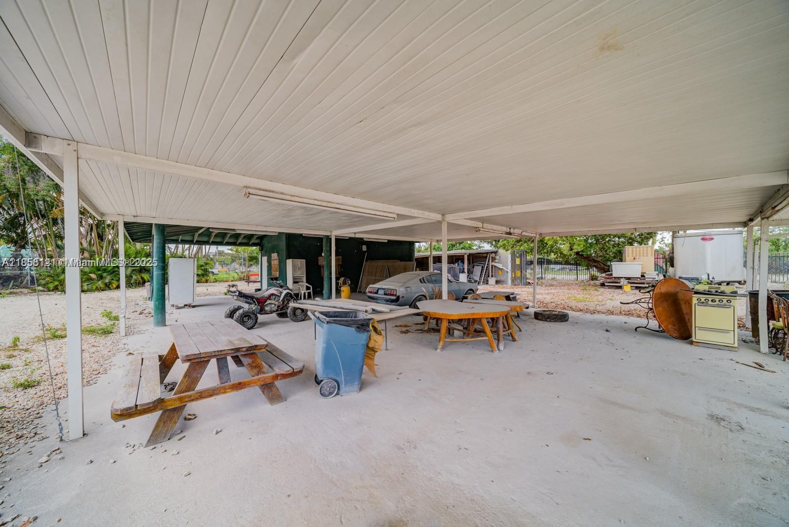 A large, covered outdoor patio features a picnic table, a car, and various miscellaneous items — 12160 NW 157 st, Miami FL 33018, MIAMI, FL