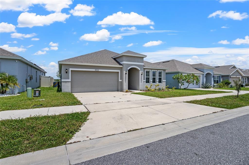 A single-story suburban house with a gray garage, stucco exterior, and a concrete driveway — 4022 ALISSA LANE, HAINES CITY, FL