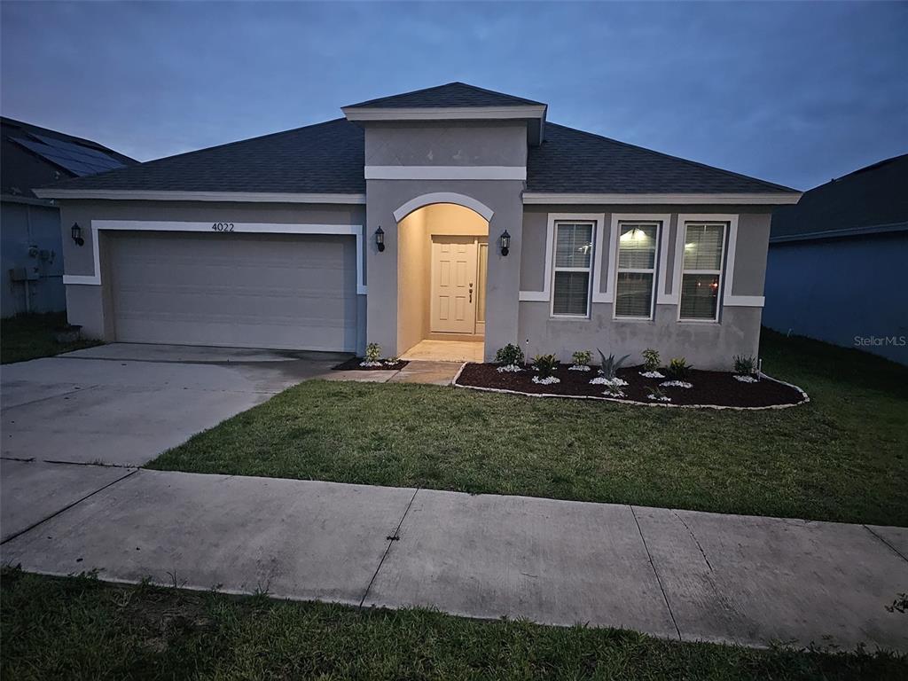 A single-story house with a gray stucco exterior, a two-car garage, and a front entryway — 4022 ALISSA LANE, HAINES CITY, FL