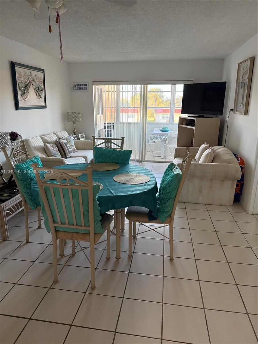 A dining area with a round table and chairs sits in front of a living room — WEST PALM BEACH, FL
