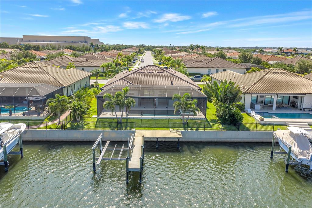 An aerial view of a waterfront house with a pool, screened lanai, and private dock — 513 17TH AVENUE E, PALMETTO, FL