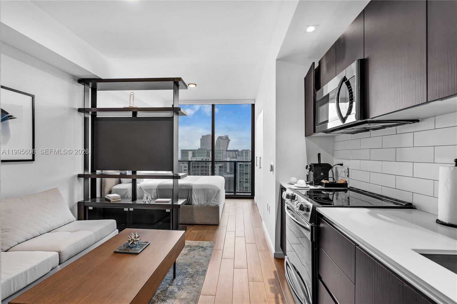 A modern studio apartment features a kitchen, living area, and bedroom separated by shelving — 398 NE 5th St # 4716, Miami FL 33132, MIAMI, FL