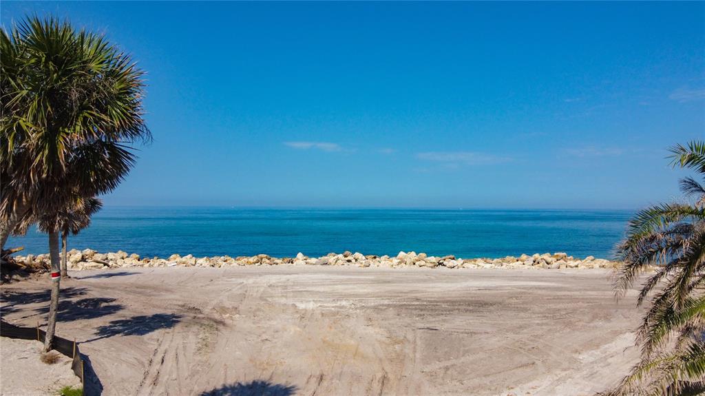 A sandy beach area with palm trees and a rocky shoreline overlooking the ocean — 7050 MANASOTA KEY ROAD, ENGLEWOOD, FL