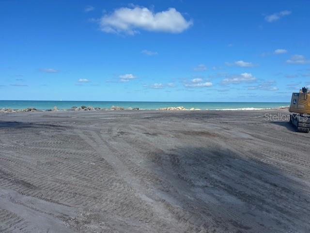 A view of a sandy beach with tire tracks and construction equipment near the water — 7050 MANASOTA KEY ROAD, ENGLEWOOD, FL