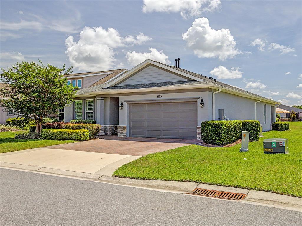 A single-story house with a gray garage, stone accents, and a paved driveway — 4235 NW 55TH COURT, OCALA, FL