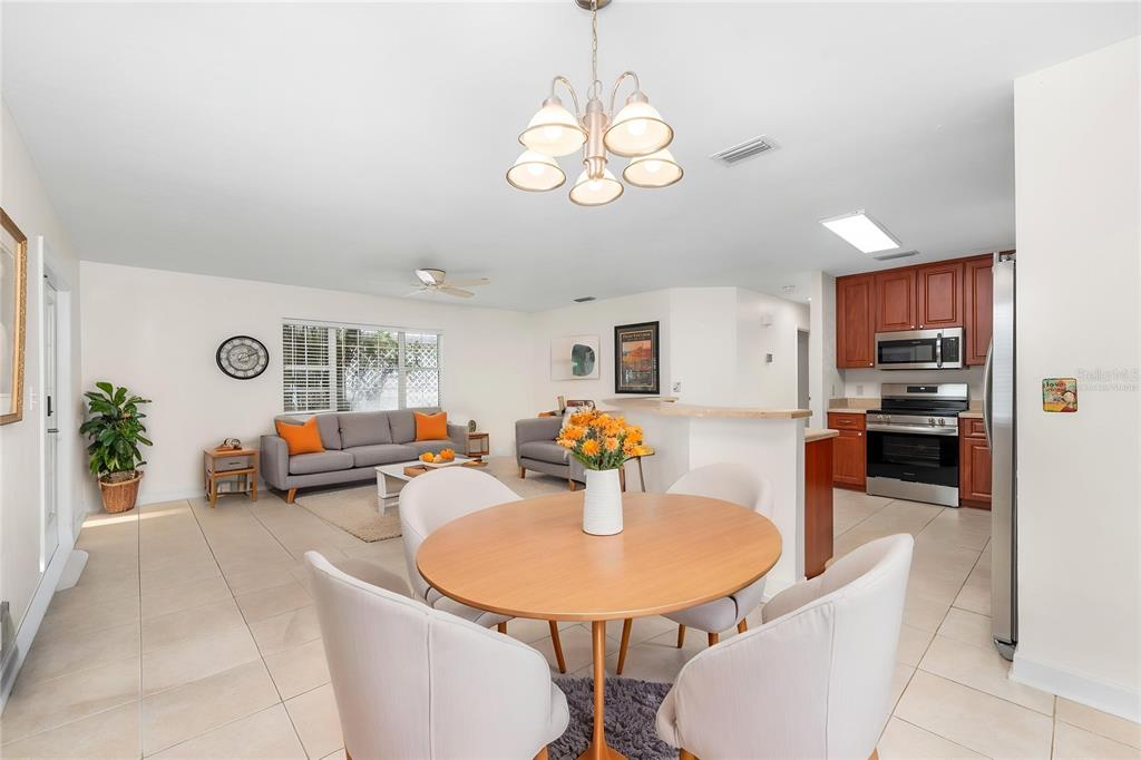 An open-concept living and dining area features tile flooring, a round table, and a kitchen — 8593 NW 41ST TERRACE, GAINESVILLE, FL