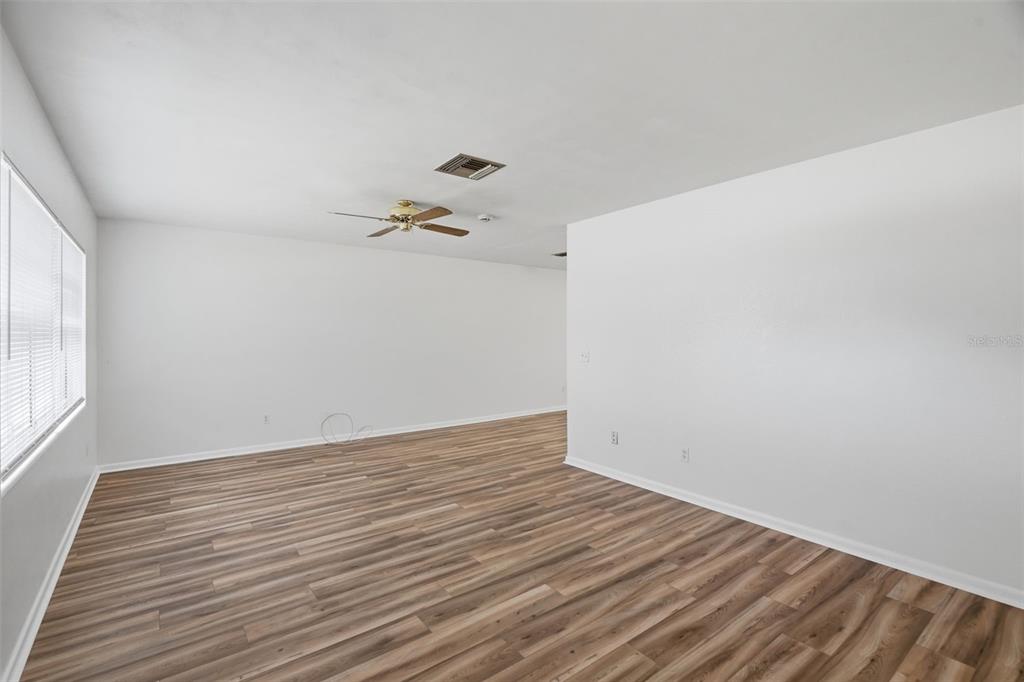 An empty room with white walls, wood-look flooring, a ceiling fan, and a window — 1981 TEMPLE TERRACE, CLEARWATER, FL