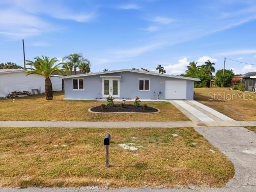 A single-story light gray house with a white garage door and a front lawn — 4127 GARDNER DRIVE, PORT CHARLOTTE, FL